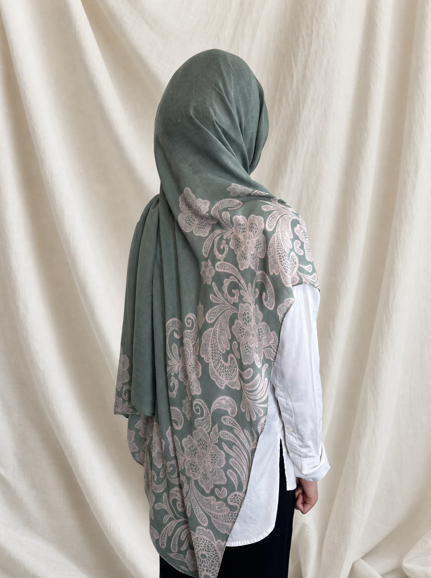 Jade Lace printed hijab by The Noorea Collection, back view, white drapery backdrop